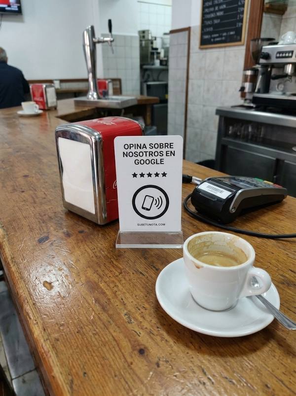 Tarjeta Sube tu nota en una base transparente, en la barra de un bar